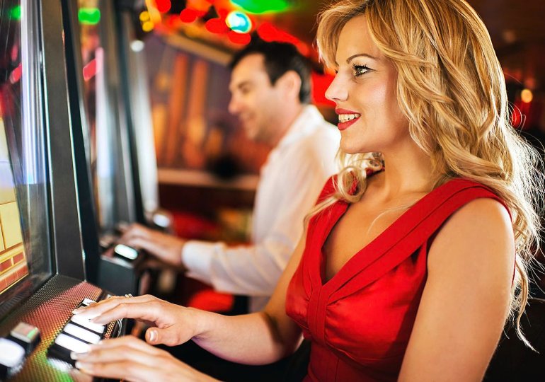 ragazza in rosso che gioca alla slot del casinò